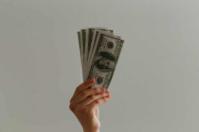 Hand holding dollars - JP Valery/Unsplash