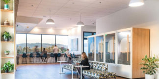 Someone working at a couch in a large open space at SOMO Cowork