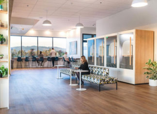Someone working at a couch in a large open space at SOMO Cowork
