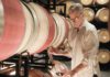 Courtney Benham of CMB Family of Wines pours a glass of wine from a barrel.