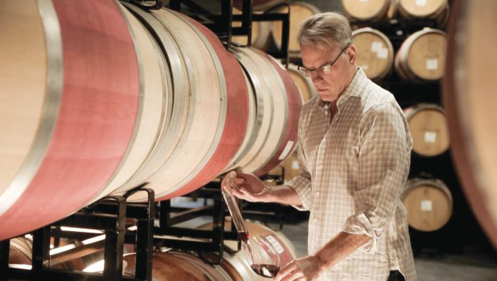 Lauded Legacy: Courtney Benham Reignites a Wine Icon Courtney Benham of CMB Family of Wines pours a glass of wine from a barrel.