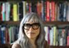 Soraya Murray, author and film scholar, photographed in front of books on shelves.