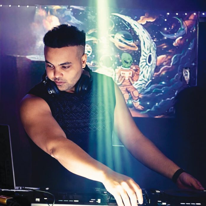 DJ and producer Mo Babiker standing with audio equipment at a Trance Goats event.