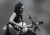 Musician Ani DiFranco performing onstage with a guitar.