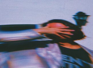 Distorted photo of a woman holding her hand across her face