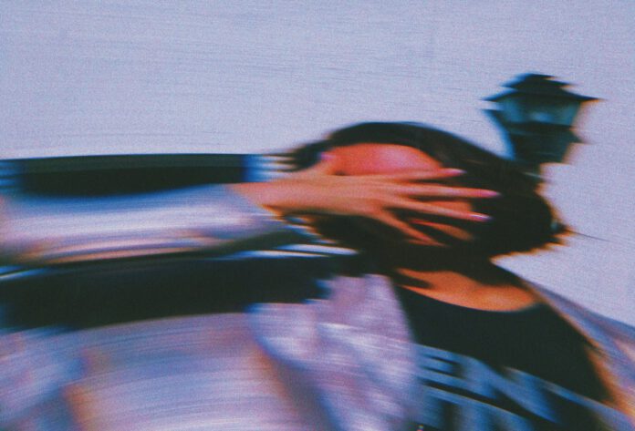 Distorted photo of a woman holding her hand across her face