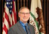 Jason Nutt, Santa Rosa's interim city manager, poses for a photograph in front of the California and American flags.
