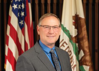Jason Nutt, Santa Rosa's interim city manager, poses for a photograph in front of the California and American flags.