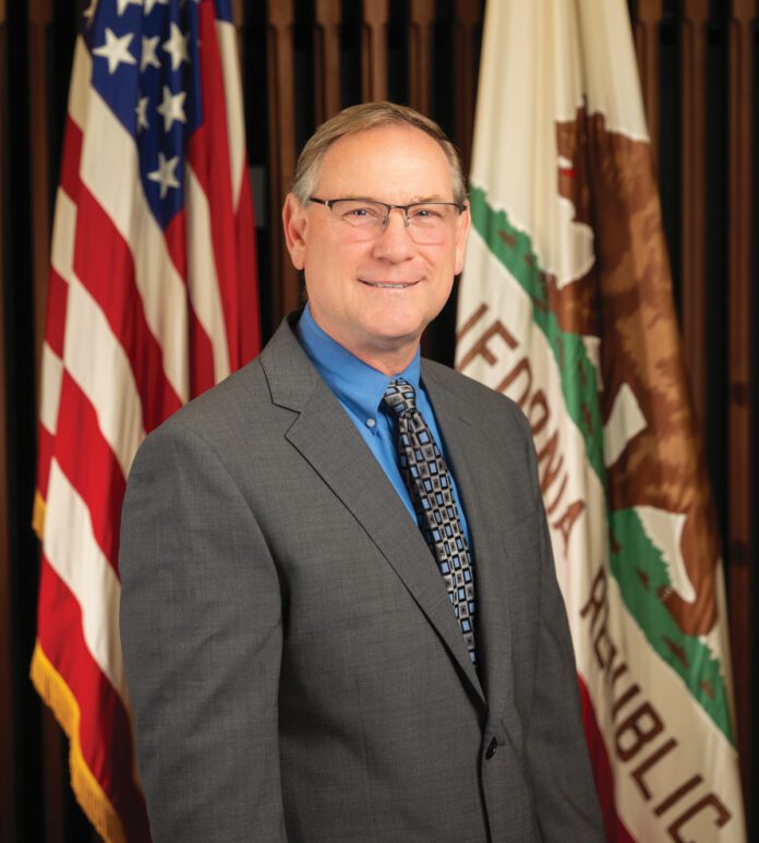 Jason Nutt, Santa Rosa's interim city manager, poses for a photograph in front of the California and American flags.