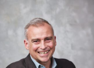 Dr. Damien Wilson wearing a dark sportscoat and blue shirt