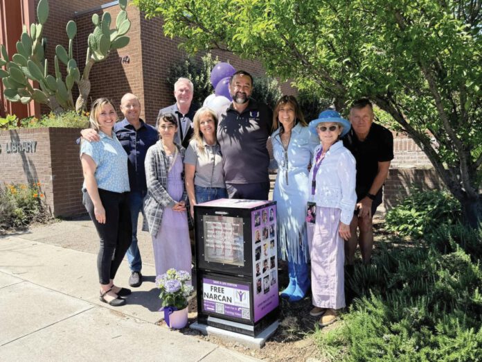 Micah’s Hugs volunteers and local officials standng beside a free Narcan box.