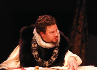 Thick Plot, ‘Equivocation’ at Spreckels A man in an Elizabethan ruff collar leans over a desk covered in papers.