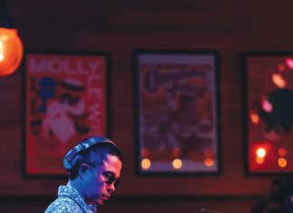 The Saint Rose Disco: Micah Perrin of Sounds Good Sonoma A man in headphones, sunglasses and a patterned shirt works the DJ controls.