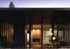 Natural Honors: Local Home Design Wins for Marin and Sonoma Counties A stone-paved walkway leads to single-story dark brown modern house with floor-to-ceiling glass windows.
